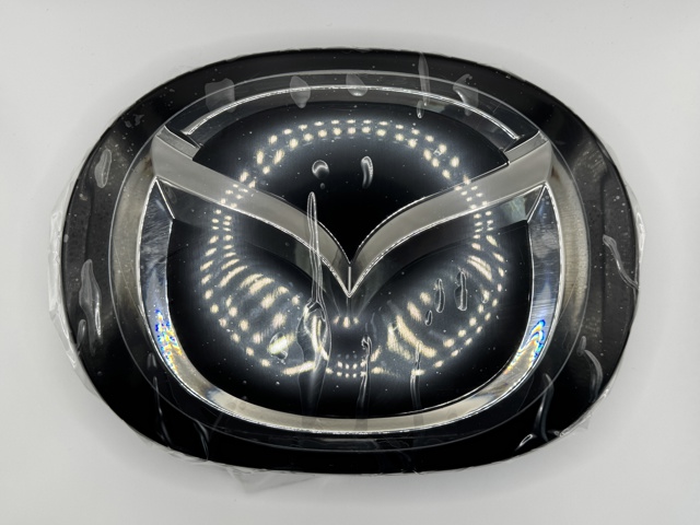 Фірмовий значок капота TK7951730 MAZDA