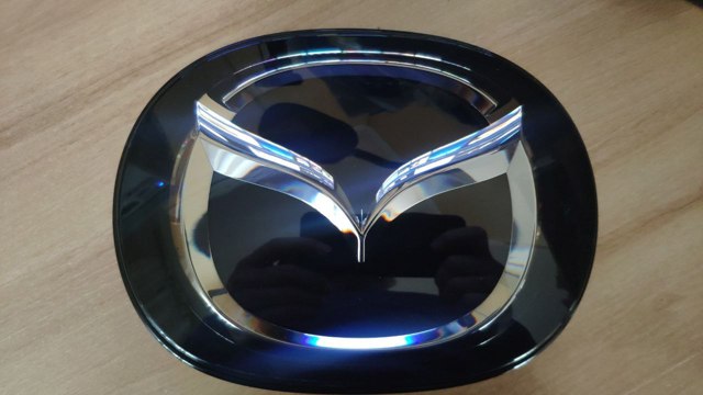 Емблема капота TK7951730 MAZDA