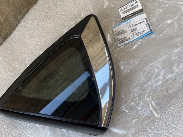 Скло багажного відсіку, ліве Mazda KB7W63950A9D